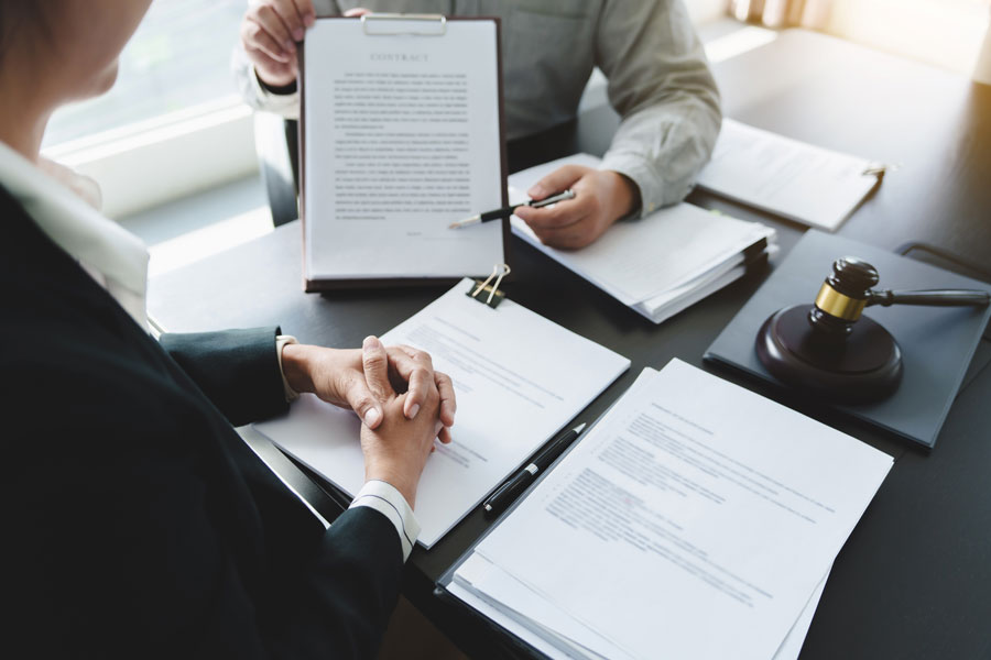 Lawyer and Client at Table reviewing a contract